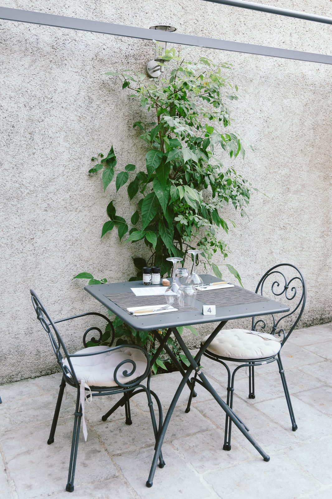 Terrasse de l'auberge avec tables et chaises en fer forgé